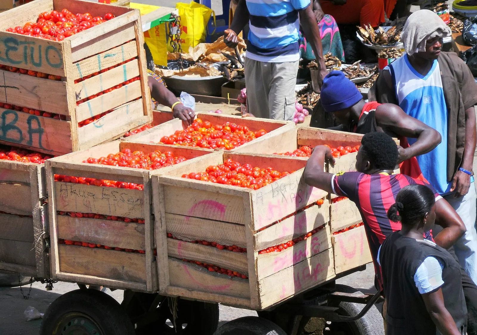 A handcart carrying goods through a busy market